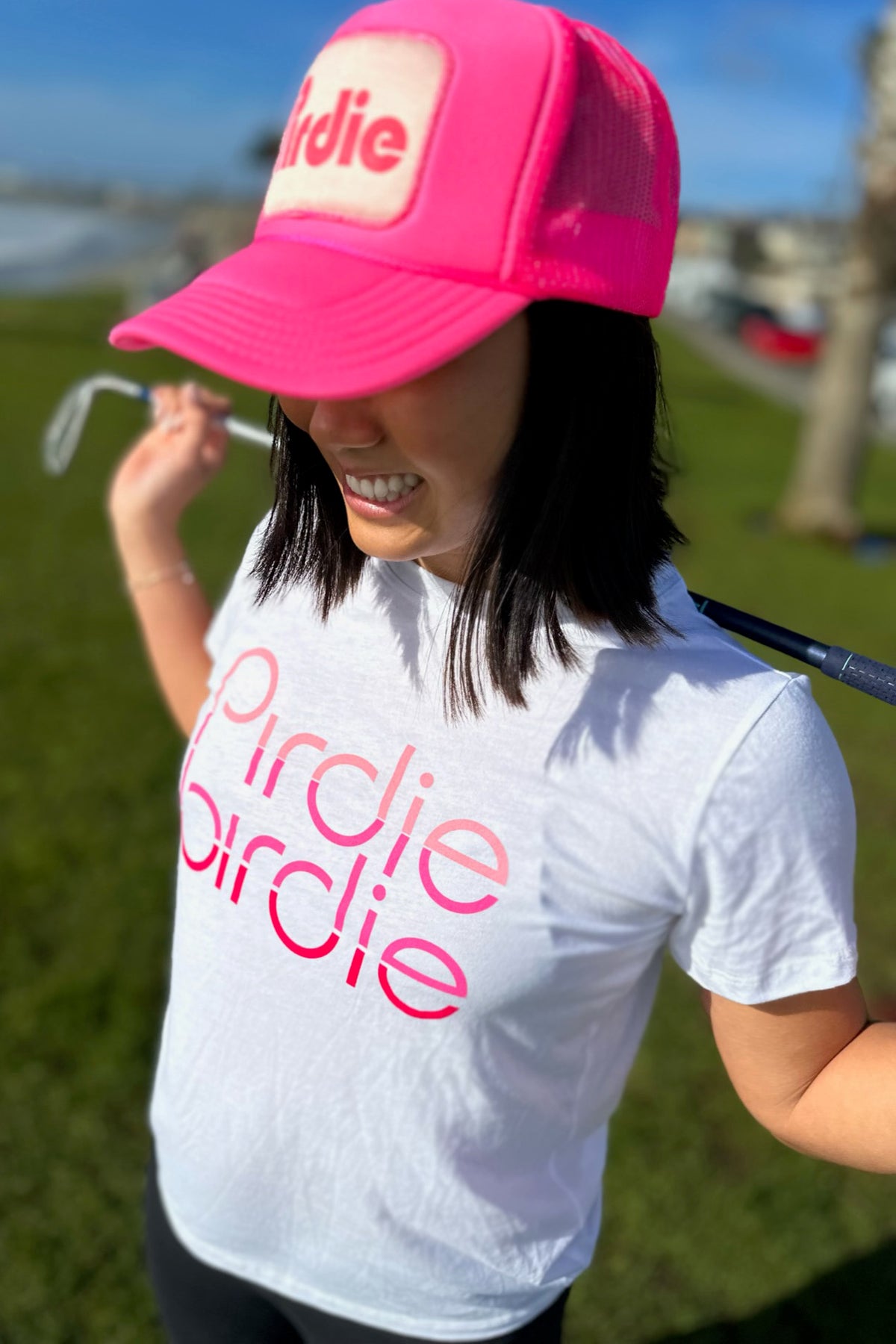 Model wearing hot pink Pirdie golf trucker hat. 
